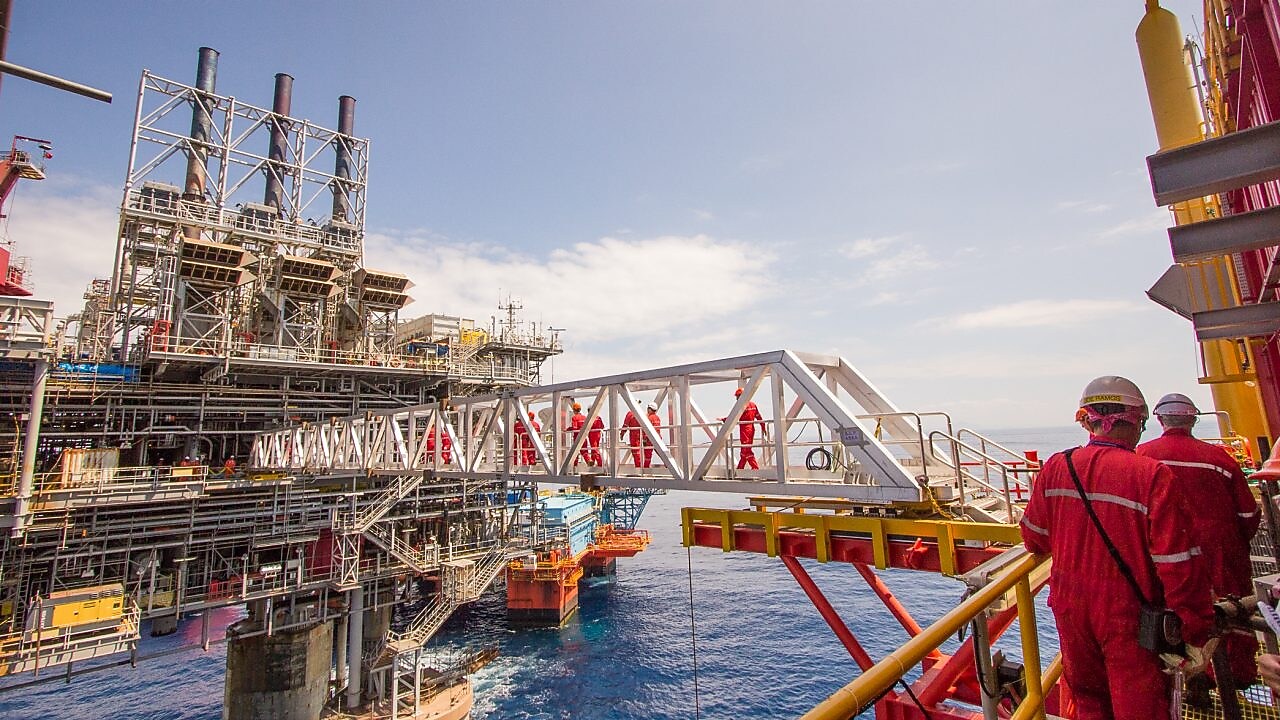 Workers cross over to a new platform built alongside the existing Malampaya deep-water project