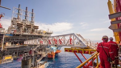 Workers cross over to a new platform built alongside the existing Malampaya deep-water project