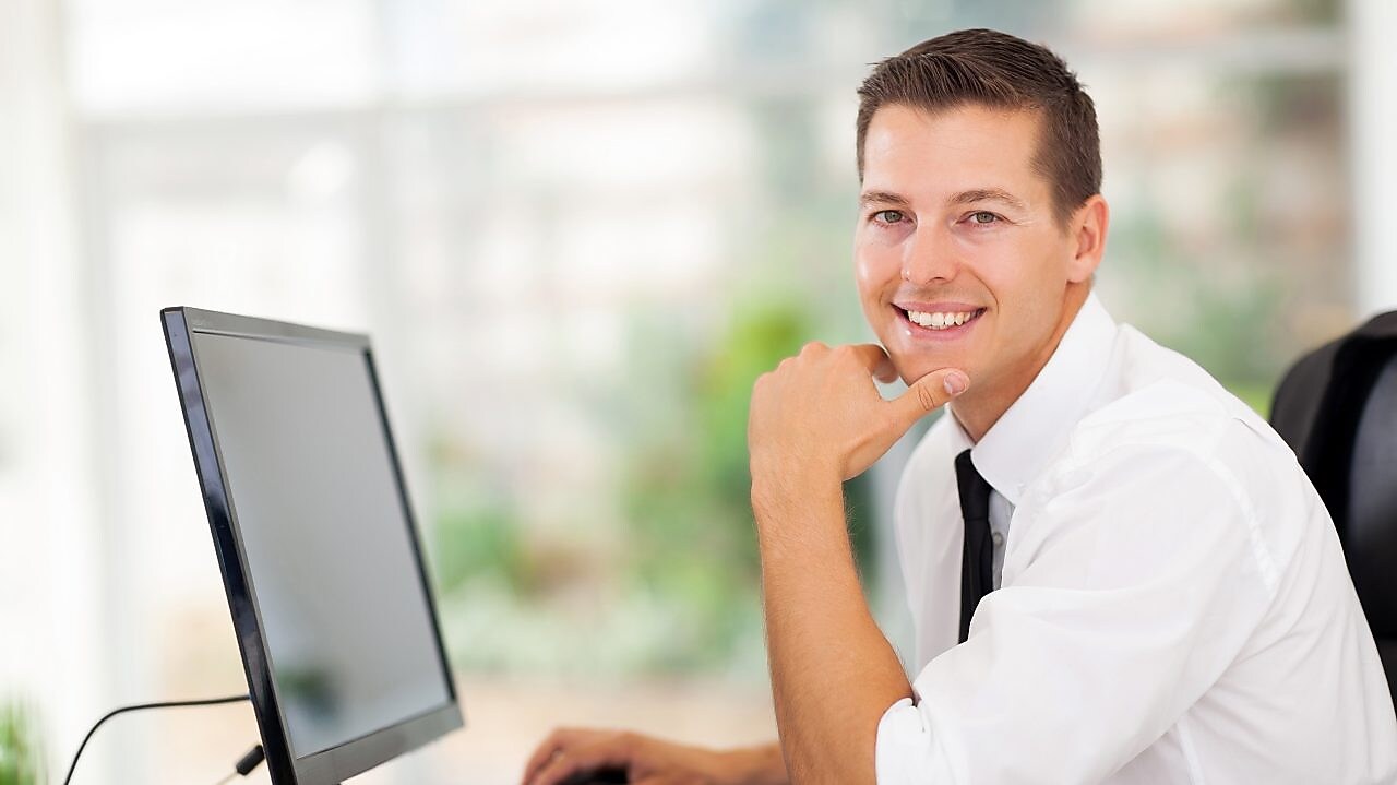 Man working on computer and smiling
