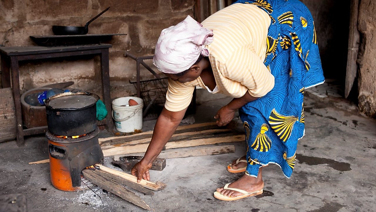Lady cooking on a cookstove in Nigeria