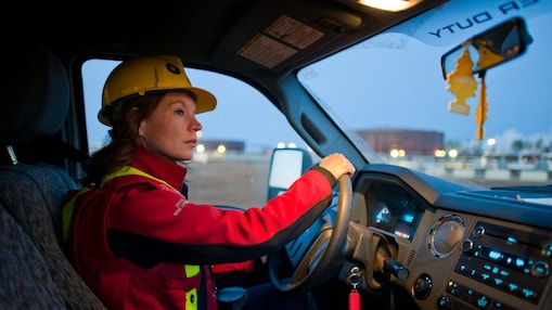 A lady wearing safety equipment driving a vehicle